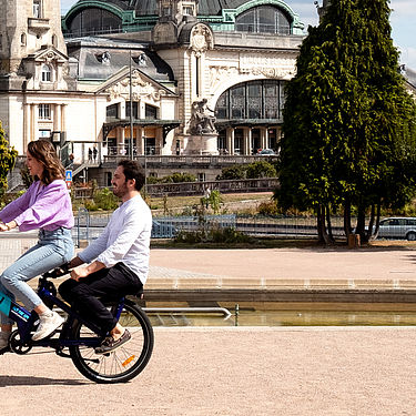 Couple sur un vélo électrique Centre-ville limoges devant la gare des Bénédictins